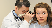 Doctor checking the ears of a patient